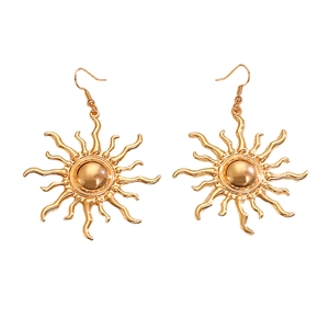 Detailed view of golden sun-shaped drop earrings with polished metallic finish