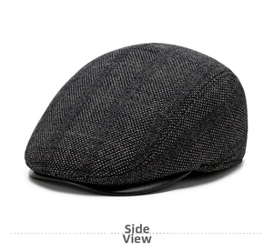 Detail of grey plaid woolen flat cap featuring a dark leather brim and woven texture