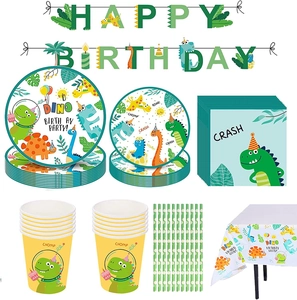 Flat lay of green dinosaur party supplies including paper plates, cups and Happy Birthday banner