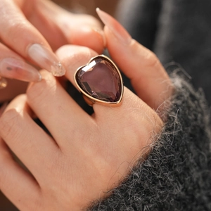 Detailed view of oversized heart-shaped purple crystal ring with gold-plated setting