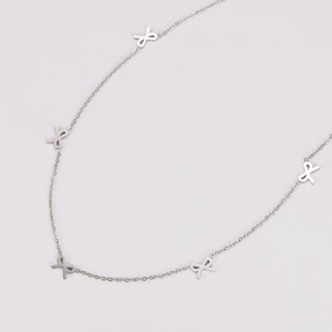 Detailed close-up of a silver stainless steel necklace with small bow pendants