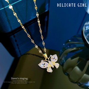 Close-up of a gold butterfly pendant necklace with sparkling pavé zircons on jewelry box