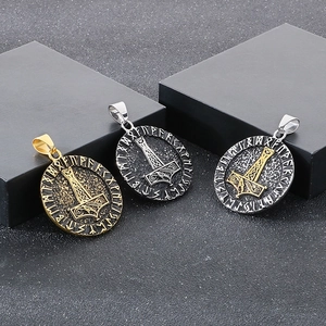 Detailed view of three Viking Thor's Hammer pendants in gold, silver, and black finishes