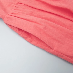 Detail view of cotton summer dress featuring a functional side pocket and gathered waist pleats