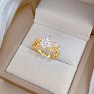 Luxurious gold floral ring with sparkling crystals on a soft beige velvet jewelry box