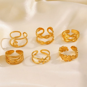Set of 6 gold adjustable rings with snake, braided, and geometric leaf patterns on silk
