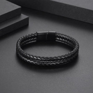 Macro detail of men's black braided double leather bracelet with black magnetic clasp