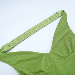 Détail de robe en maille scintillante verte avec col en V et texture froncée