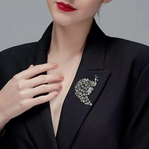 Elegant crystal peacock brooch with blue rhinestones on a black suit lapel