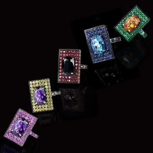 Set of five wide square rings with colorful gemstones on a professional black background