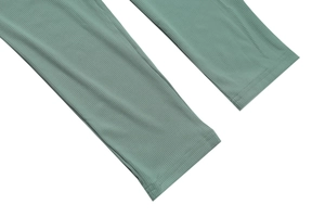 Detailed close-up of sage green ribbed knit leggings with reinforced double-stitch hem
