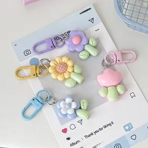 Close-up of four macaron-colored resin flower keychains with matching lobster clasps