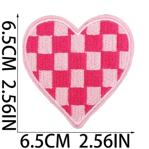 Detail view of 6.5cm pink checkerboard heart embroidery patch showing texture and size