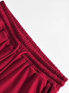 Detailed macro view of red linen pants featuring an elastic drawstring waistband