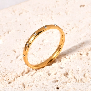 Macro detail of a 18k gold-plated dainty ring with sparkling inlaid zircon stones