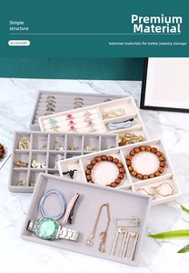 Detail view of beige and grey velvet jewelry trays with ring slots and large compartments