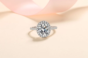 Macro view of oval cut moissanite ring with halo setting and pavé diamonds on silver band