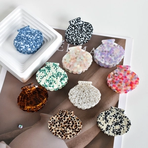 Set of 10 minimalist shell-shaped acetate hair claws in various stylish marble patterns