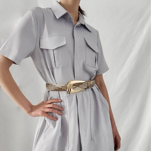 Detail of hand-woven metallic fiber belt with oversized irregular gold metal buckle