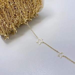 Detail of 14k gold-plated metal chain with hollow star charms on white spool