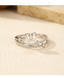 Macro detail of silver heart-shaped moissanite ring with elegant crisscross band design