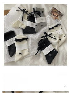Detail of sweet cotton socks with ribbon bows, lace trim, and delicate polka dot patterns