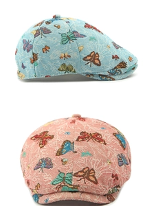 Detail of vintage floral butterfly jacquard fabric on stylish british newsboy caps