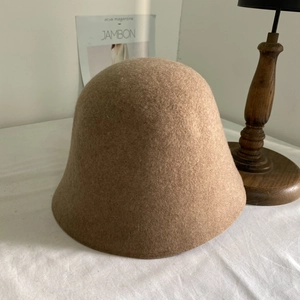 Texture détaillée d'un chapeau cloche en feutre de laine camel dans un décor rétro