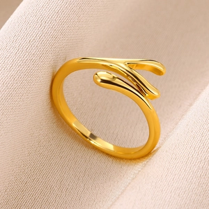 Detail of a minimalist gold teardrop ring with a polished finish on textured silk