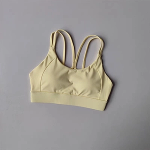 Detail view of the pale yellow sports bra showing thin criss-cross back straps design