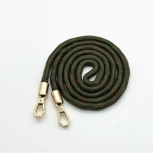 Dettaglio di cinturino in tessuto verde scuro con accenti rossi e fibbie in metallo oro