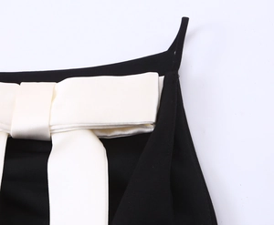 Detail einer weißen Satinschleife auf einem schicken schwarzen Modetops für Damen