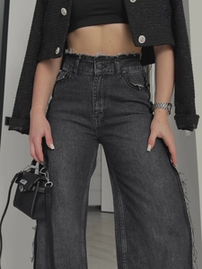 Graue High-Waist-Jeans mit Fransen-Design und schwarzer Tweedjacke im modernen Vintage-Stil