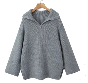 Detail of grey ribbed knit sweater featuring half-zip collar and loose silhouette design