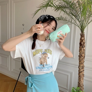 Detail of a mint green zipper pouch held by a model in casual lifestyle setting