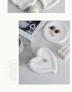 Flat lay of matte white heart and round ceramic jewelry trays for modern home decor