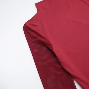 Detail of wine red dress showing chic mesh patchwork sleeves and knitted fabric texture