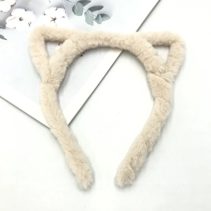 Detailed view of plush cat ear headband texture in beige faux fur on a white background