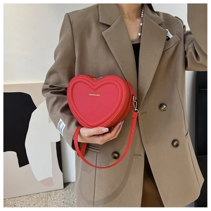 Dettaglio della borsa a tracolla rossa a forma di cuore in pelle PU opaca con metallo oro