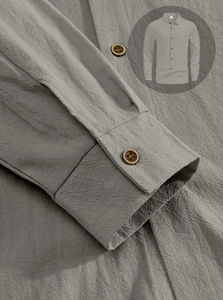 Detailed close-up of dark grey linen shirt showing sleeve cuffs and premium fabric texture