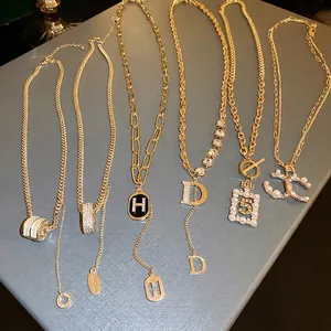 Elegant gold necklaces set with diamond encrusted letters and pearls on leather