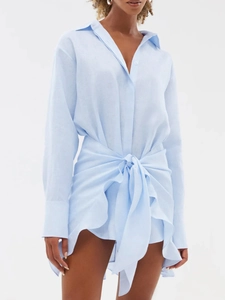 Detailed texture of light blue linen shirt dress featuring waist tie and turn-down collar