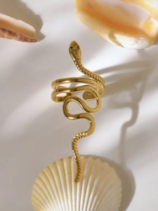 Macro di anello a serpente dorato a tre strati su base beige con conchiglie naturali