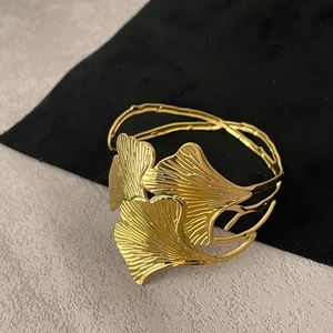 Close-up of golden stainless steel ginkgo leaf bracelet with detailed etched texture