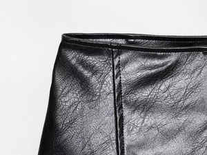Détail des coutures et de la texture d'un ensemble veste et short en similicuir noir