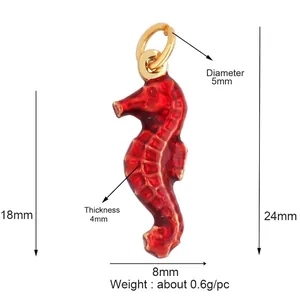 Macro detail of red enamel seahorse charm with golden metal edges and size dimensions