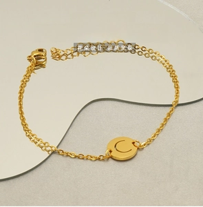 Close-up of gold stainless steel bracelet with a hollow letter C round pendant