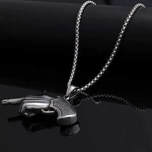 Detailed macro shot of silver stainless steel revolver pistol pendant with metal texture
