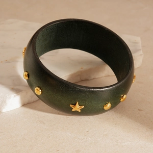 Detailed view of a dark green wood texture bangle with golden stars and rivets