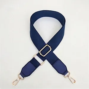 Close-up of dark blue canvas strap featuring adjustable golden metal hooks and texture